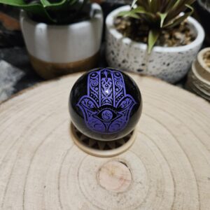 Imperial Fialová Hamsa Obsidián – Sféra božskej ochrany (Prírodná čierna obsidiánová guľa s gravírovaným fialovým symbolom Hamsa – priemer 5 cm)
